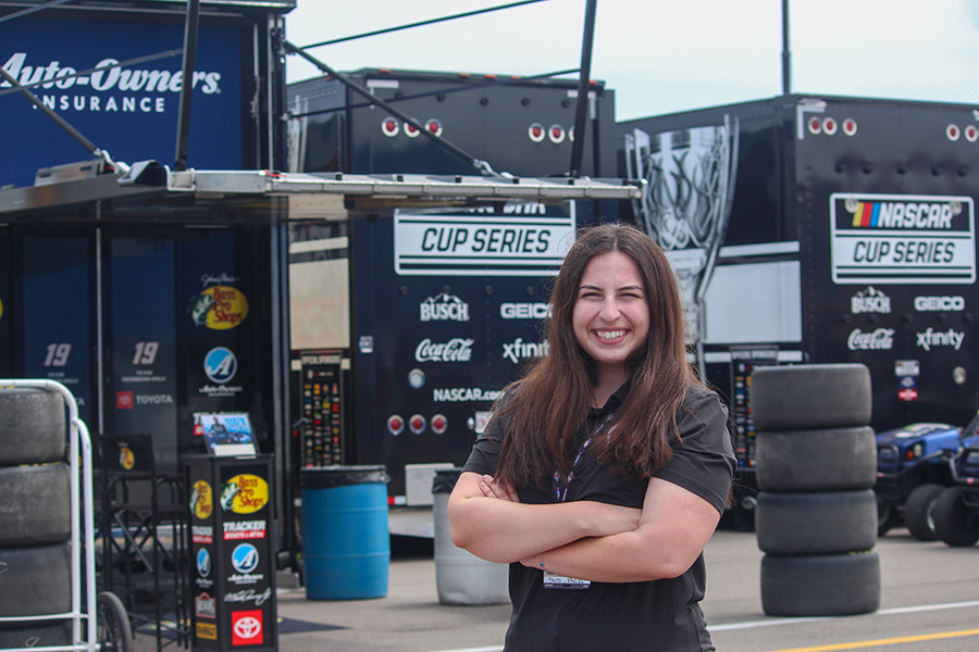 Sara Xhaja stands by NASCAR team trailers