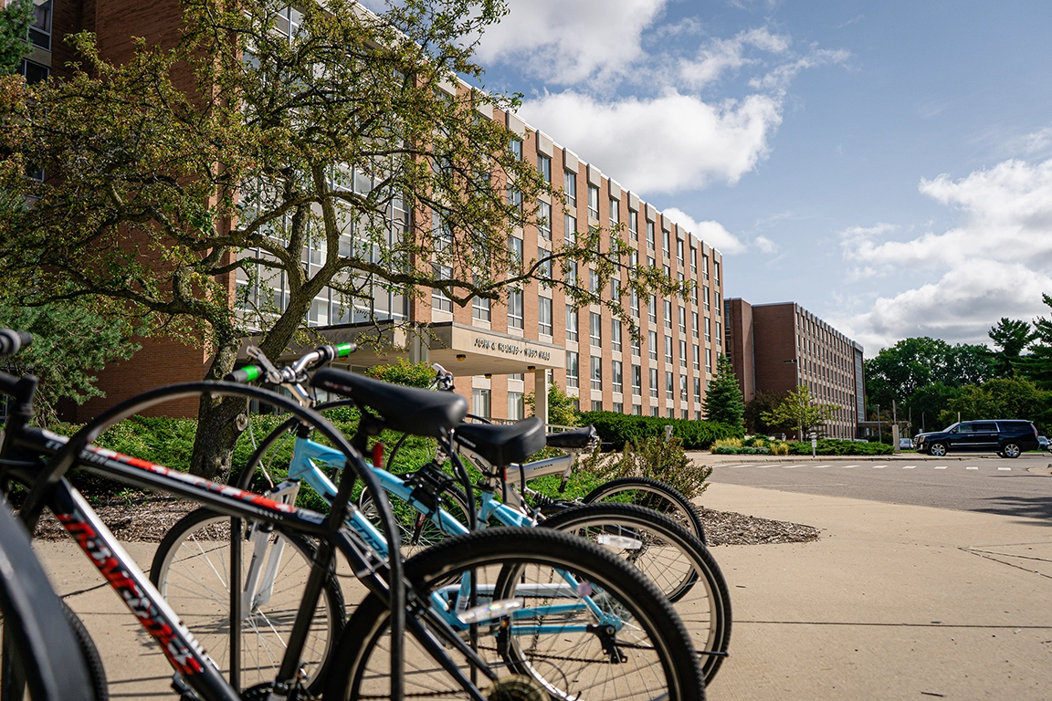 Bikes chained to a rack outside of Holmes Hall, a Midcentury modern residence hall on the campus of Michigan State University