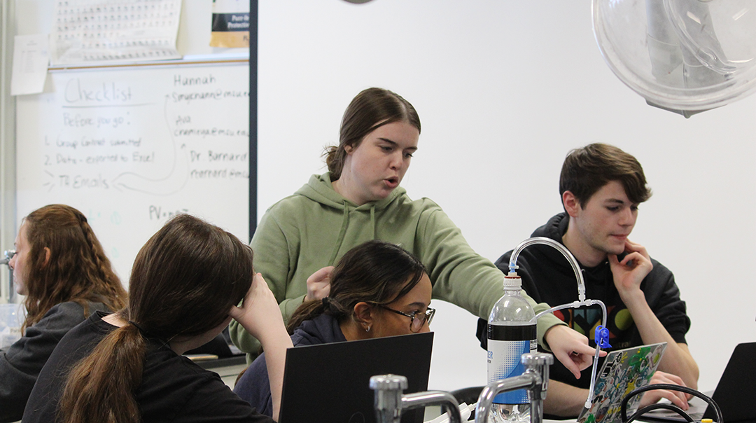 A ULA supports students in a chem lab