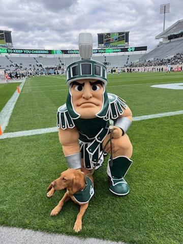 John Morrison in Sparty costume, poses with Zeke the Wonderdog before a football game