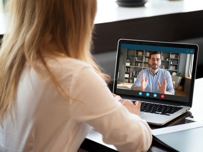 a person listens intently to another on an online interview