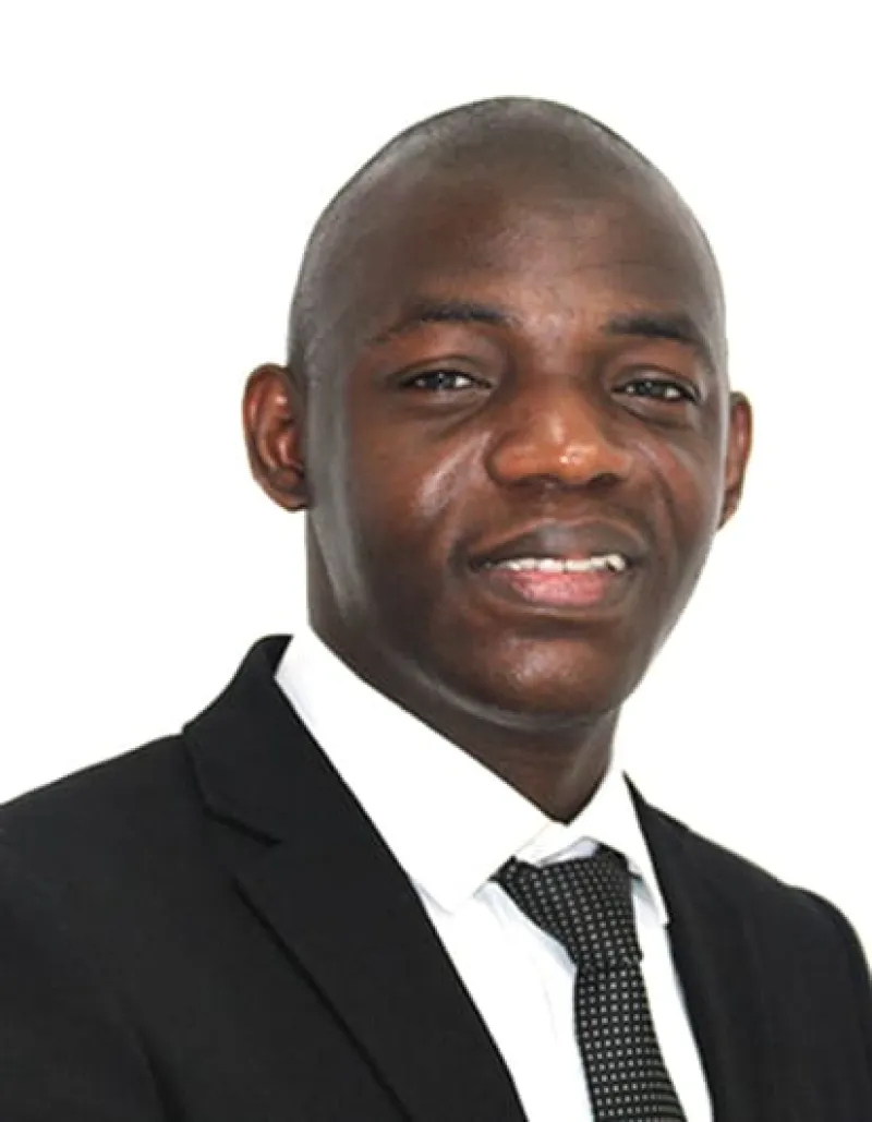 Prudence Djagba smiles. He is wearing a suit and tie.