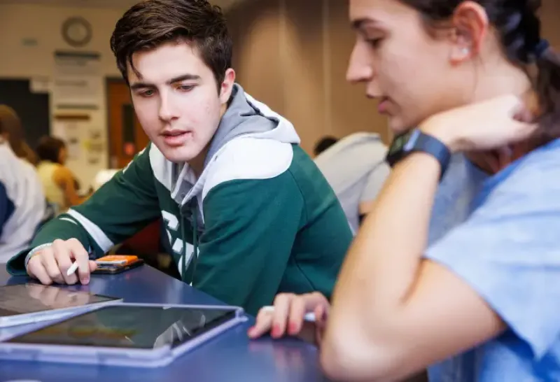 Students working together on a tablet