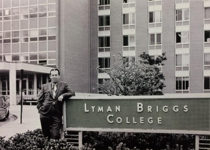 F.B. Dutton, the inaugural dean of Lyman Briggs College, by a sign for Lyman Briggs College, outside of West Holmes Hall. Photo from 1967