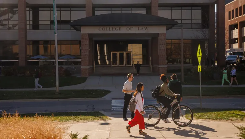 Students walking and riding a bike on campus