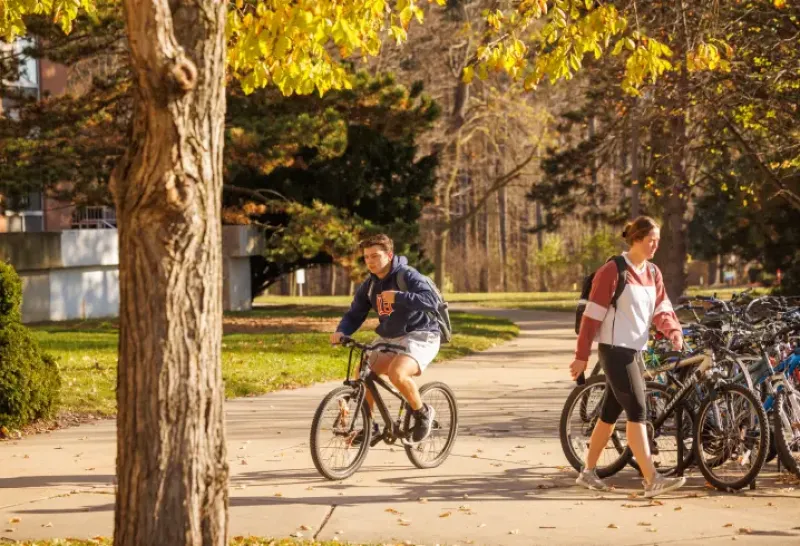 Student riding a bike on campus